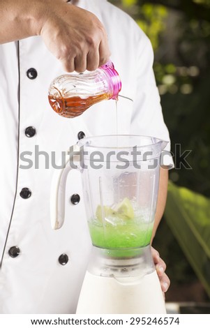 Chef putting Syrup to the Blender for making green apple smoothie