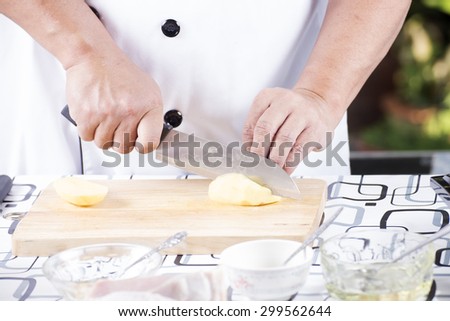 Chef cutting Potato on wooden broad / Cooking Japanese pork curry concept
