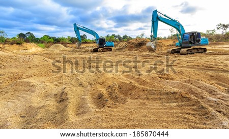 Wheel loader Excavator with backhoe loading sand at eathmoving works in construction site
