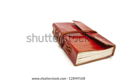 Old leather-bound book with parchment paper inside on a white background