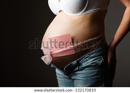 Pregnant woman torso with a note to write the name