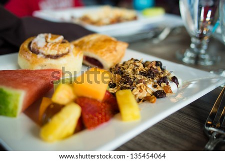 Breakfast with yogurt, cereals, fruits and pastries