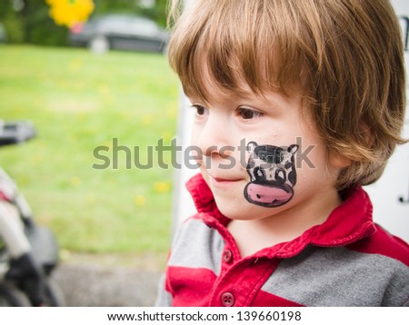 Boy with a cow drawing on his face