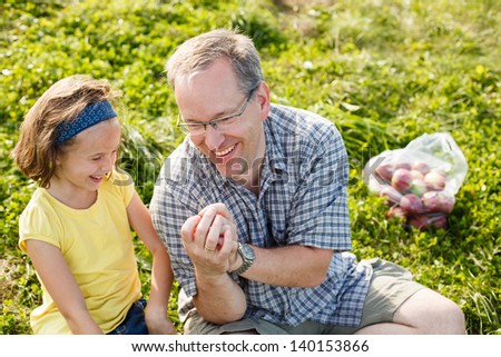 Father teaching how to whistle with grass to his daughter