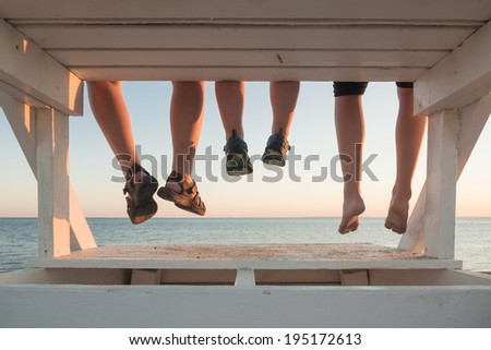 Family with their feet hanging at sunset in Cape Cod