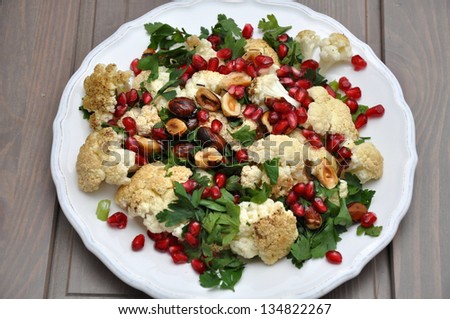 Vegetable salad with cauliflower, roasted hazelnuts and pomegranate seeds