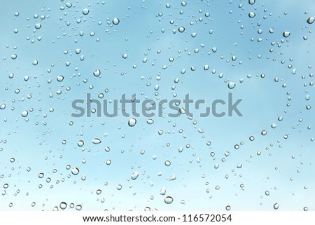 Heart from gentle droplets of a rain on clean transparent glass