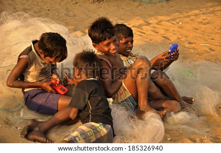 KONARK, INDIA - JANUARY 23: A Group of village kids in India playing video games in Konark, India on January 23, 2010