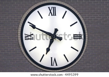 Clock with backlighting at dusk showing eleven minutes before seven