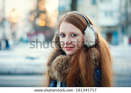 red-haired girl with freckles and blue eyes in a winter city