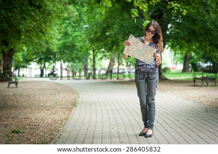 young woman looking on the map at he city park