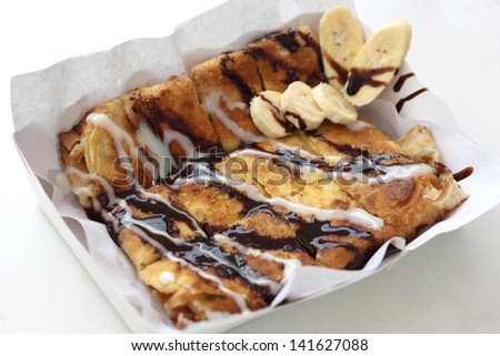 Dessert style of fried Roti with banana cooking on the street in Bangkok, Thailand