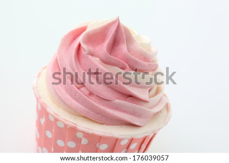 Cupcake with swirls of creamy strawberry frosting on white background Macro