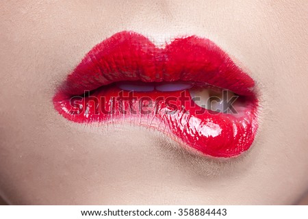 Closeup of sensuous woman biting pink lips