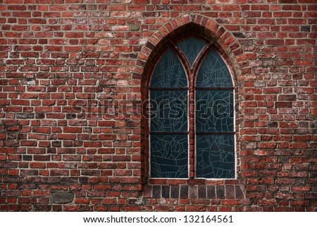 Gothic brick wall with a window, a stained glass window