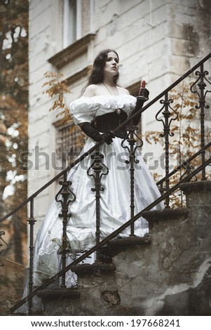 Mysterious woman in a white Victorian dress. The stylized photo at old