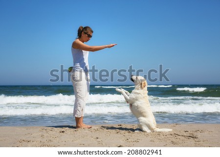 Woman plays with dog on beach