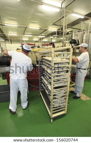 JIJONA, ALICANTE PROVINCE, SPAIN - September 13, 2012: Operators fill the stone mill for nougat manufacturing