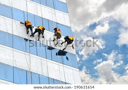 group of workers cleaning windows on high rise building