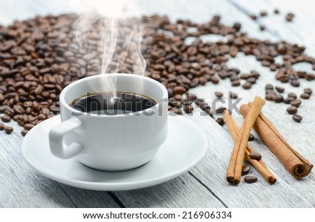 Coffee cup with smoke and coffee beans around