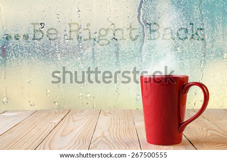 red coffee cup with smoke on water drops glass window background with text \