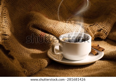 White coffee cup with smoke and coffee beans around