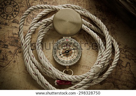 Vintage compass with rope on old map