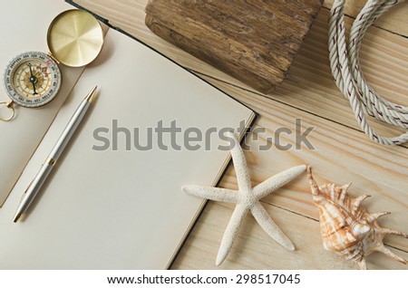 blank paper with pen and compass on sea-shells background