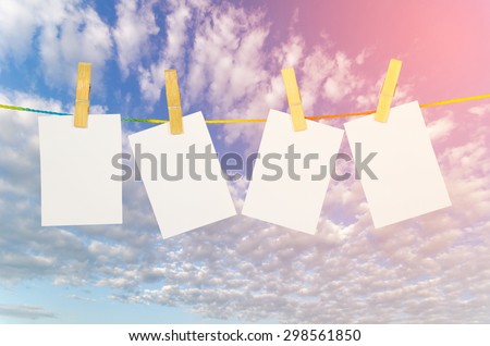 empty white photographs hanging on a clothesline with Blue Sky background