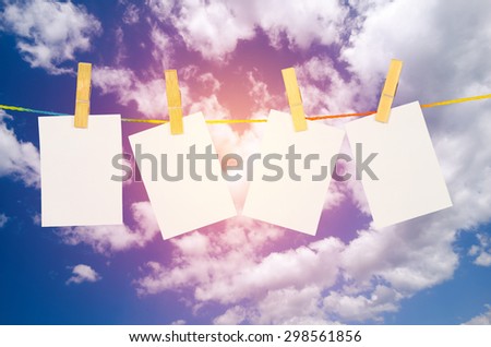 empty white photographs hanging on a clothesline with Blue Sky background