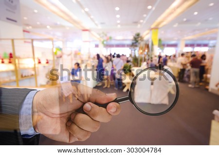 business man hand holding magnifier searching something , business concept