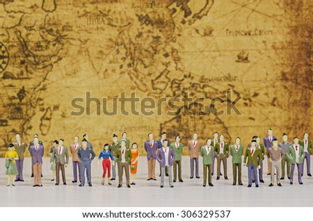 Miniature people on vintage map background