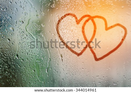 draw couple heart on natural water drops glass window background