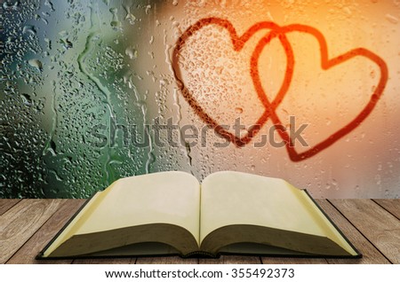 open book with water drop on glass window couple heart sign