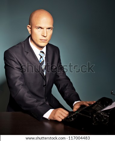 handsome bold man typing with old typewriter . secret agent typing message
