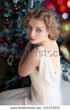 beautiful blonde woman near Christmas tree in retro style blurred