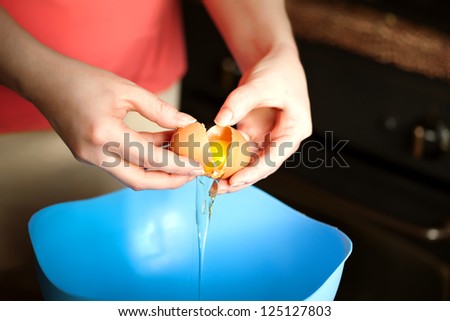 Plus size attractive woman preparing cupcake for her boyfriend in Valentine day . crashing eggs, dividing white of the eggs and yolk, beating  eggs and mixing dough