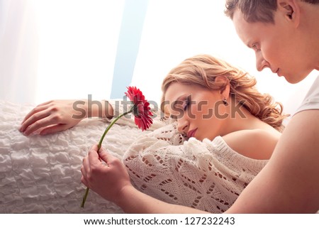 Mature couple of lovers. Man presents flower sleeping woman