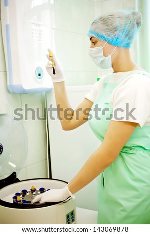 Medical doctor woman looking on test tube with blood