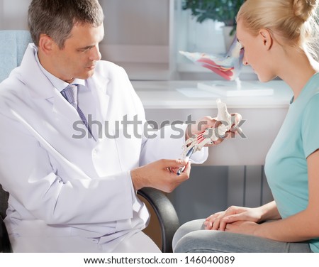 Orthopedic doctor in his office with the model of the feet
