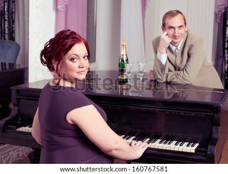 Pregnant red haired plus size woman play piano, looking at camera,husband sing song
