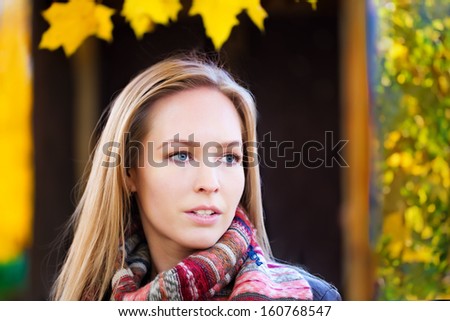 Beautiful blonde woman in autumn park,.cold,flu