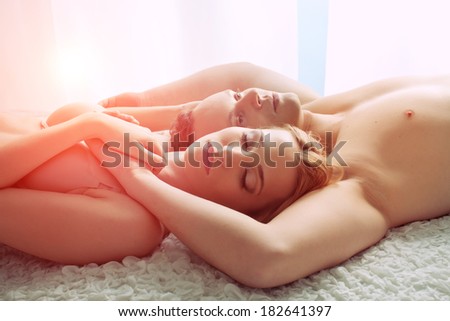 Sexy young couple lay in bed - only lingerie. Sunset or sunrise