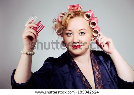 pin up plus size blonde girl posing with hair curlers, making hair