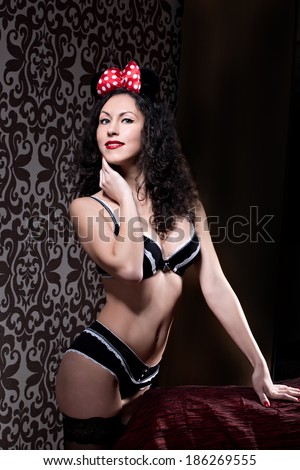 Brunette pin up model posing dressed in underwear and bow of  Minnie Mouse