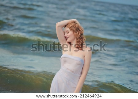 girl wearing wet white  dress  going out of the water . soft focus for tenderness