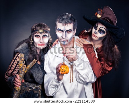 Three adults dressed in Halloween costumes.