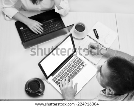 Businessman and businesswoman working on his laptop having coffee