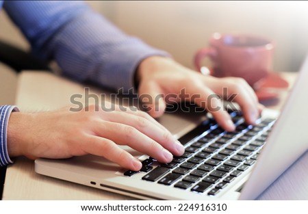 Businessman  working on his laptop having coffee