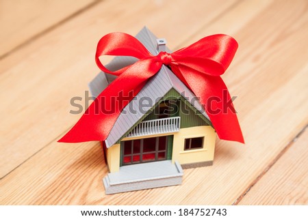house with red ribbon on wooden floor